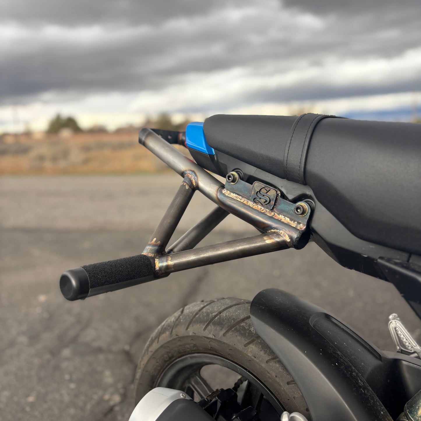 Metal bike frame components on a pegboard with tools